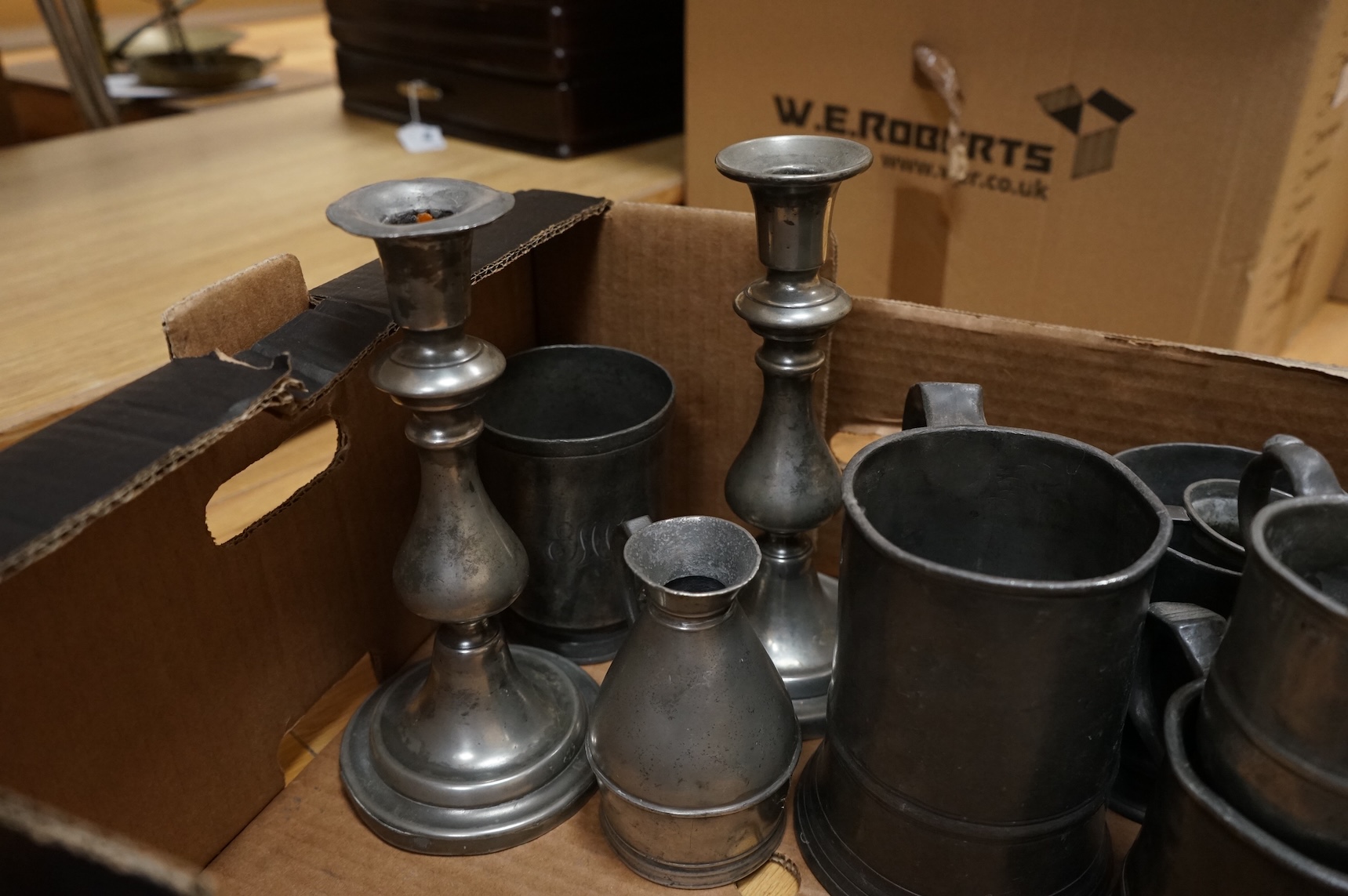 A quantity of pewter to include tankards, dishes and a pair of candlesticks